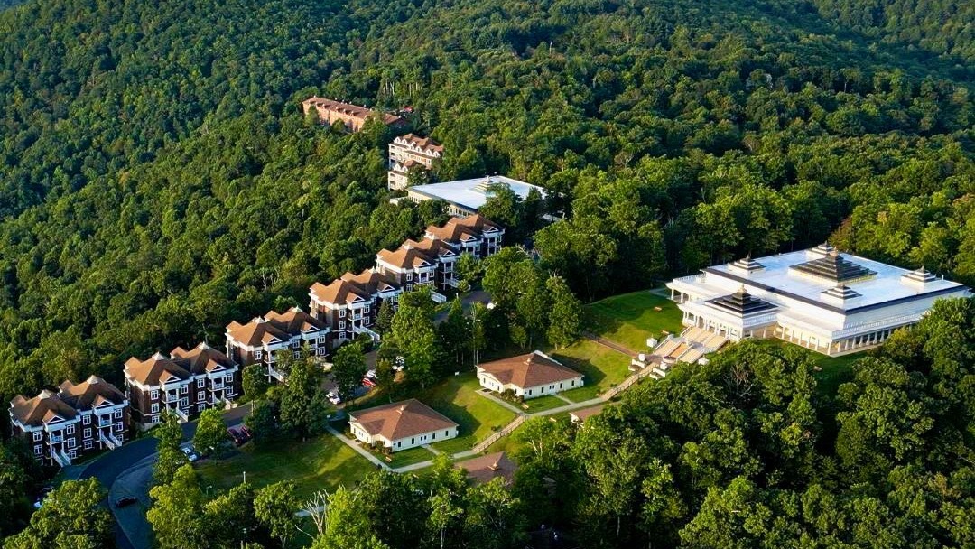 An aerial view of a retreat nestled into a forested mountainside